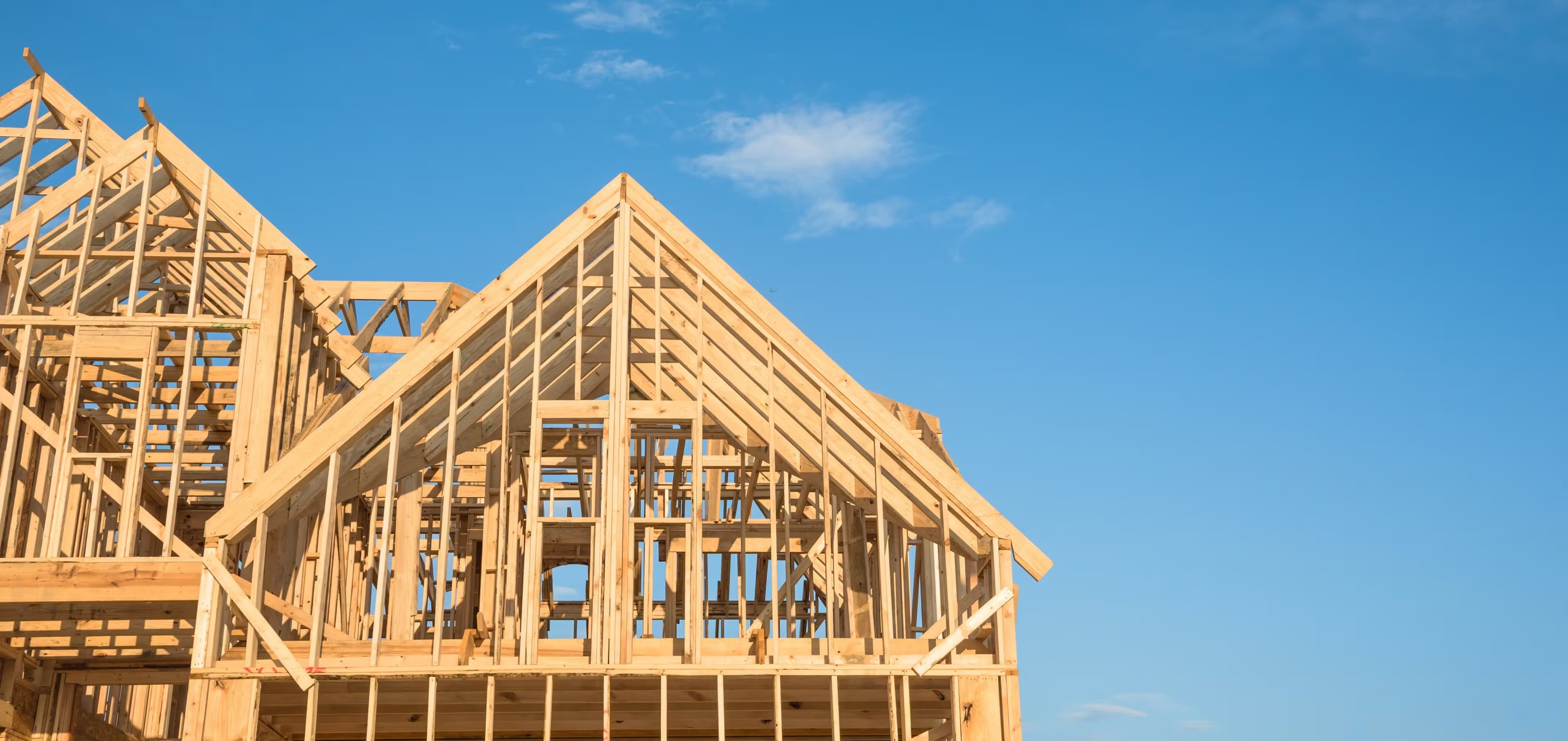 New construction wood framing under a clear sky